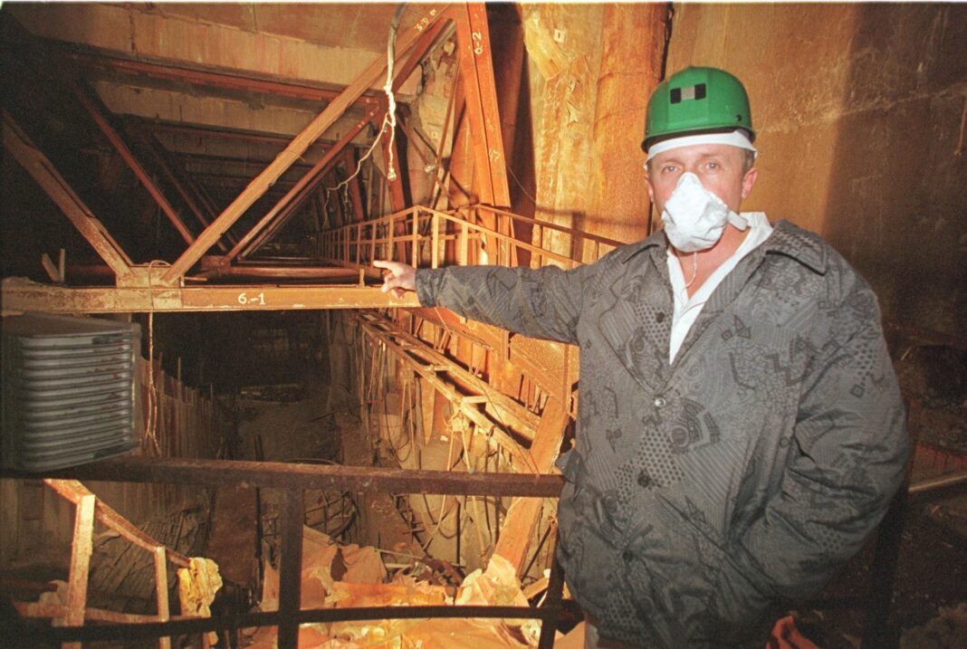 Vista del reactor número 4 de Chernobyl cubierto por el Nuevo Confinamiento Seguro, con la noria oxidada de Pripyat al fondo