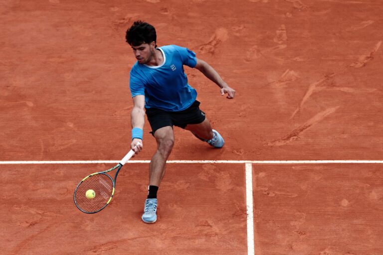 Carlos Alcaraz y Jannik Sinner durante un partido de tenis.