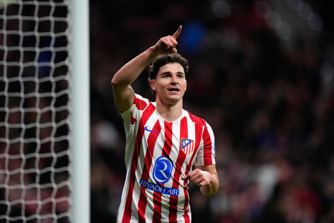 Los escudos del Atlético de Madrid y el FC Barcelona frente a frente, con el logo de la UEFA Champions League de fondo.