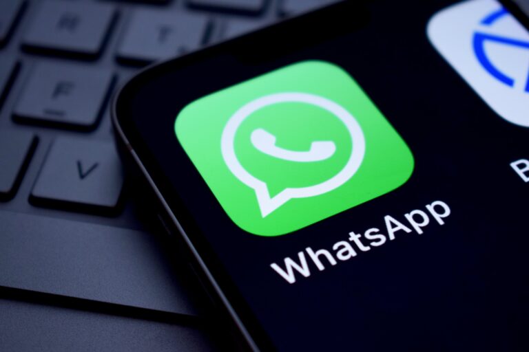 Ilustración de un teléfono móvil mostrando la aplicación de WhatsApp con un escudo de seguridad superpuesto.