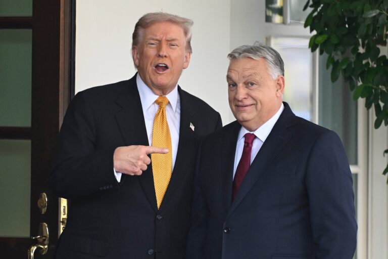Viktor Orban hablando en un podio con la bandera de Hungría de fondo.