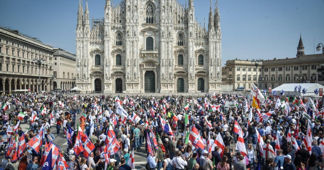 Agrupación de personas y dirigentes políticos en un acto en la Piazza del Duomo de Milán, Italia.
