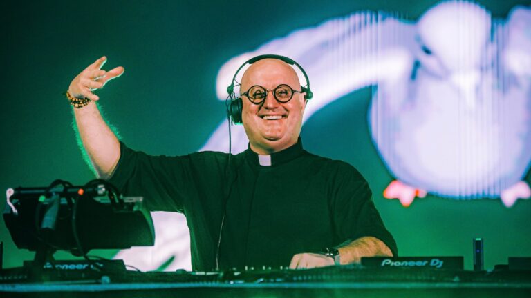 DJ Padre Guilherme durante una presentación musical frente a un público.