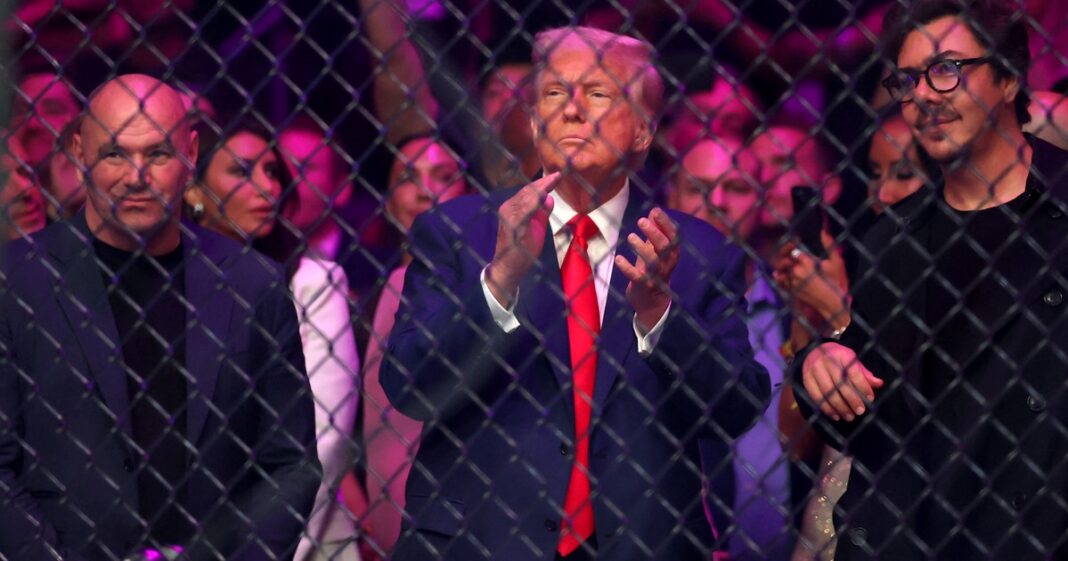Donald Trump ingresa al Kaseya Center de Miami para el evento UFC 327, acompañado por seguridad.