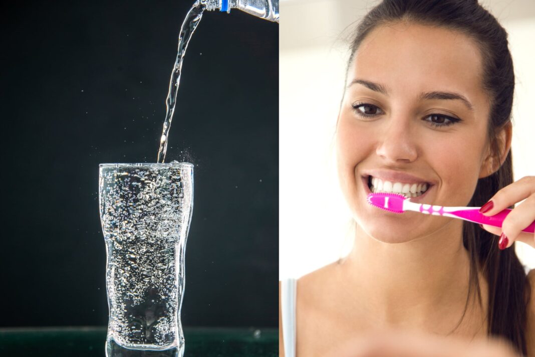 Vaso de agua con gas y un cepillo de dientes sobre fondo blanco, representando el cuidado dental.