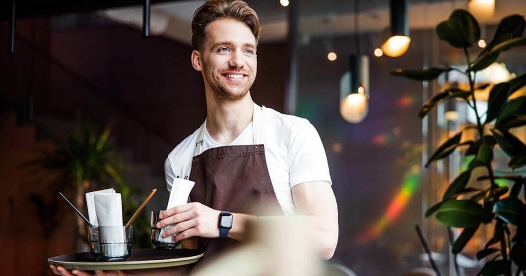 Mesero atendiendo a clientes en un restaurante concurrido de Texas