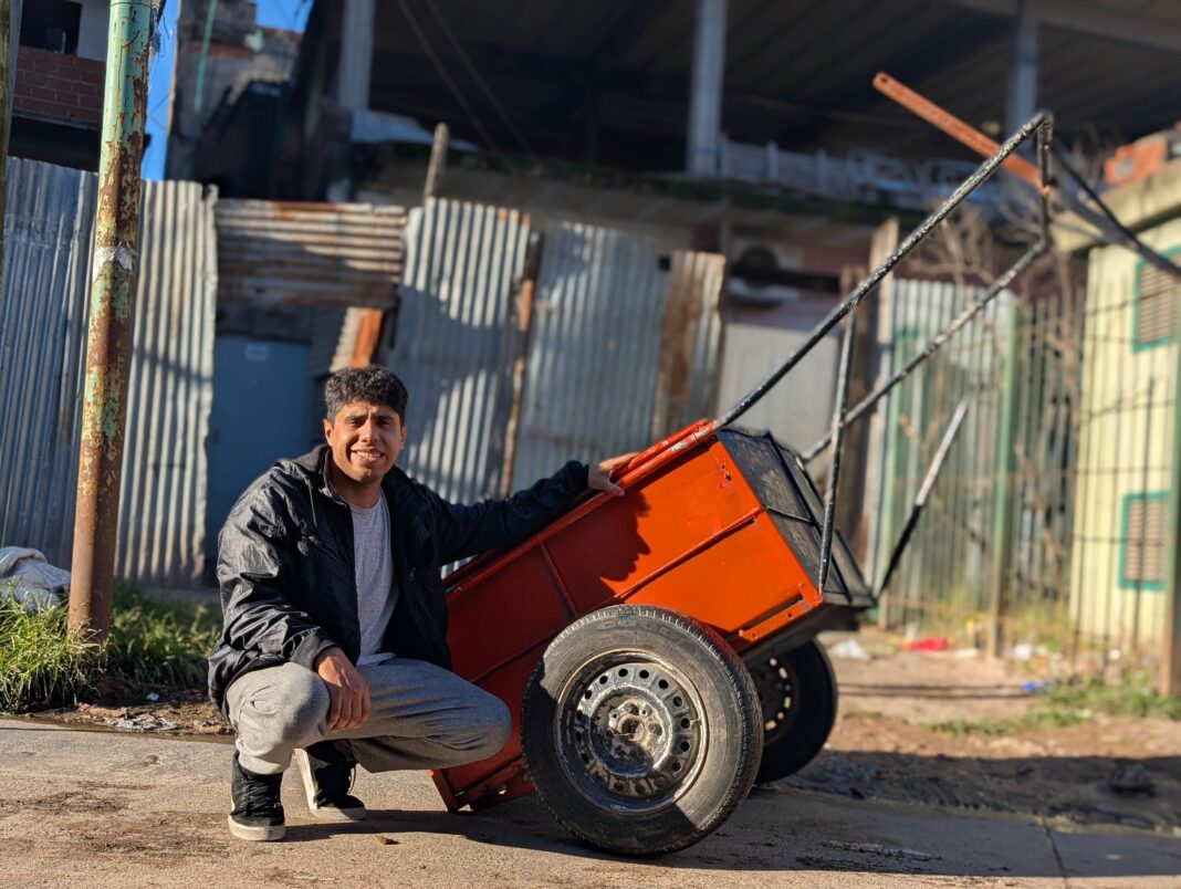 Joven preparando y repartiendo comida en un carrito por las calles de Villa Lugano
