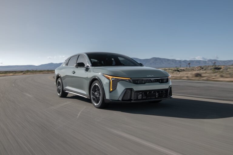 Vista frontal del nuevo sedán Kia K4, color gris, destacando su diseño con luces en forma de T y líneas aerodinámicas.