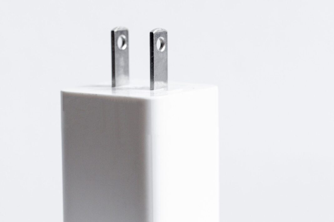 Primer plano de un enchufe tipo A con orificios visibles en sus patas metálicas