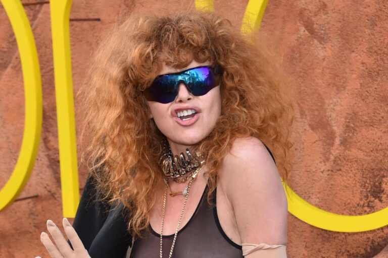 Retrato de la actriz Natasha Lyonne sonriendo, con fondo neutro.