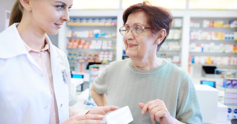 Persona mayor sosteniendo medicamentos y anteojos, símbolo de los beneficios de salud de PAMI.