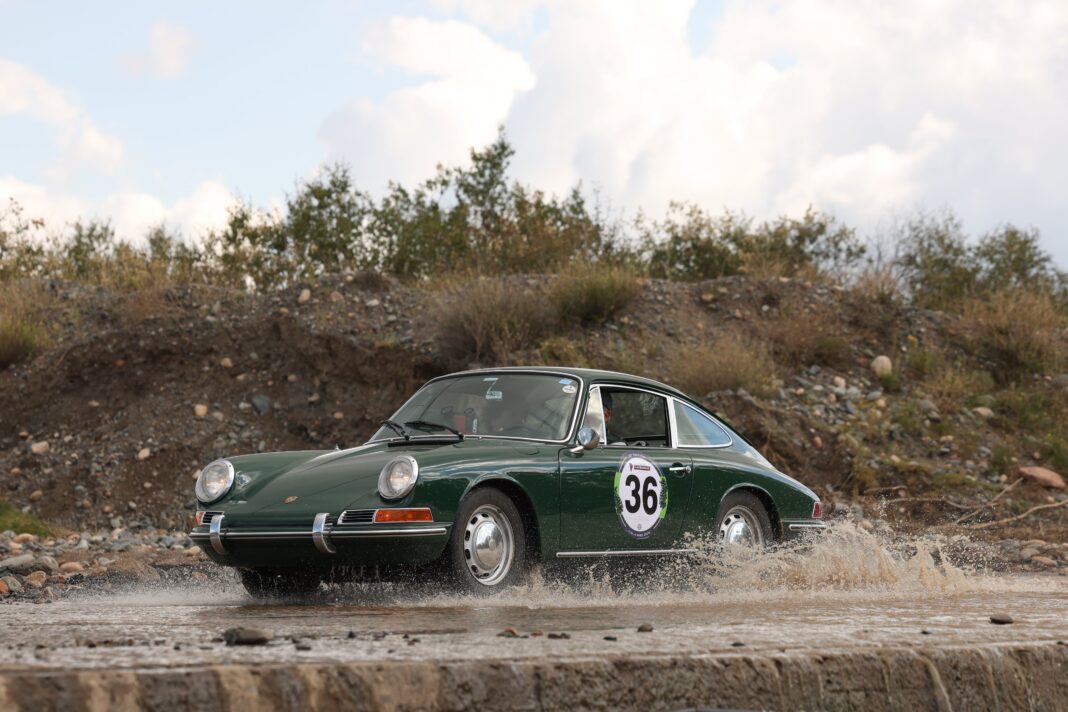 Vista de autos clásicos deportivos alineados en un rally, con el entorno de los Lagos de Palermo de fondo.