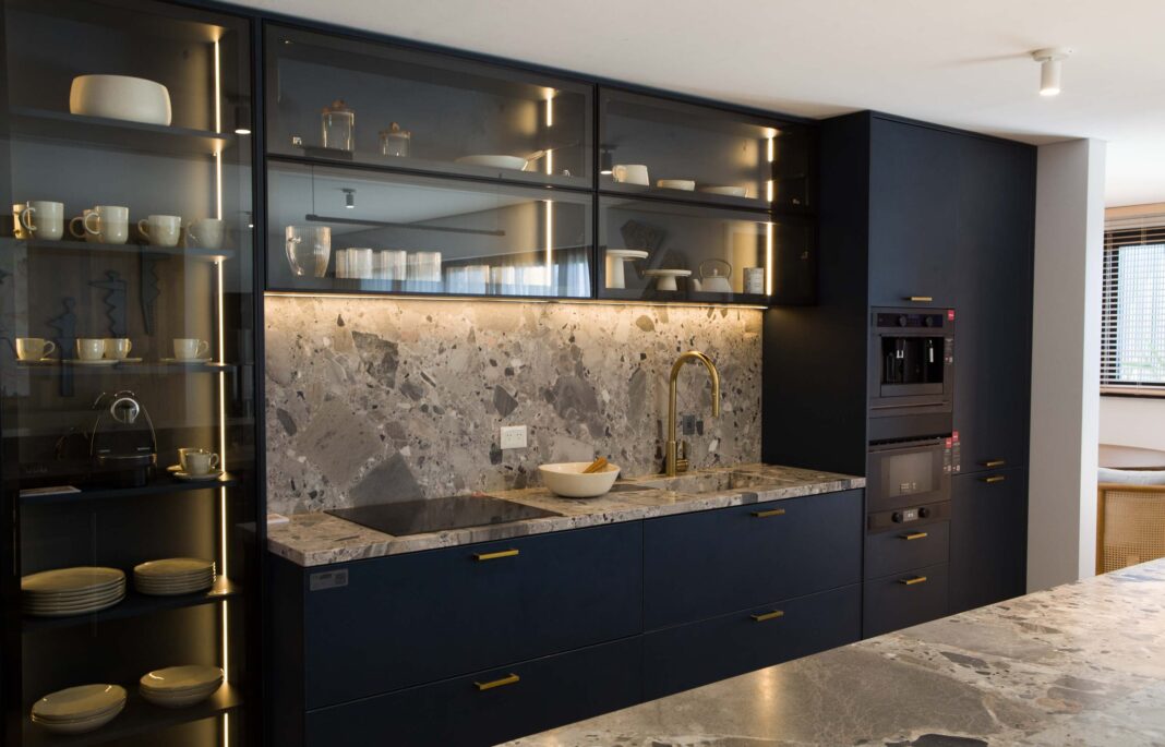 Arquitecto analizando planos de remodelación de cocina en una mesa de trabajo