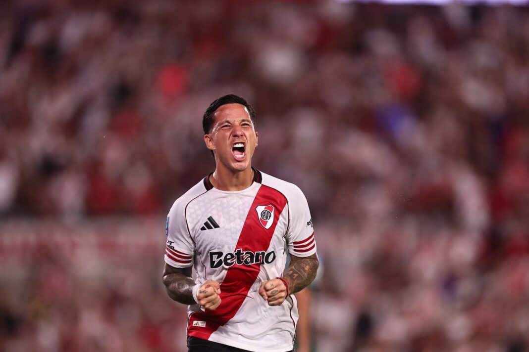 Escudos de River Plate y Belgrano de Córdoba enfrentados, con el estadio Monumental de fondo.