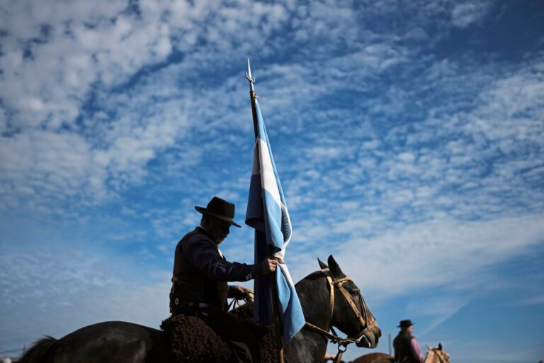 Festival tradicionalista con gauchos y caballos en campo argentino durante celebraciones del 25 de Mayo