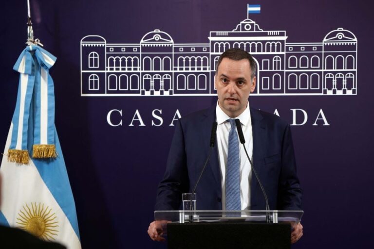 Sala de periodistas en Casa Rosada con micrófonos y banderas argentinas