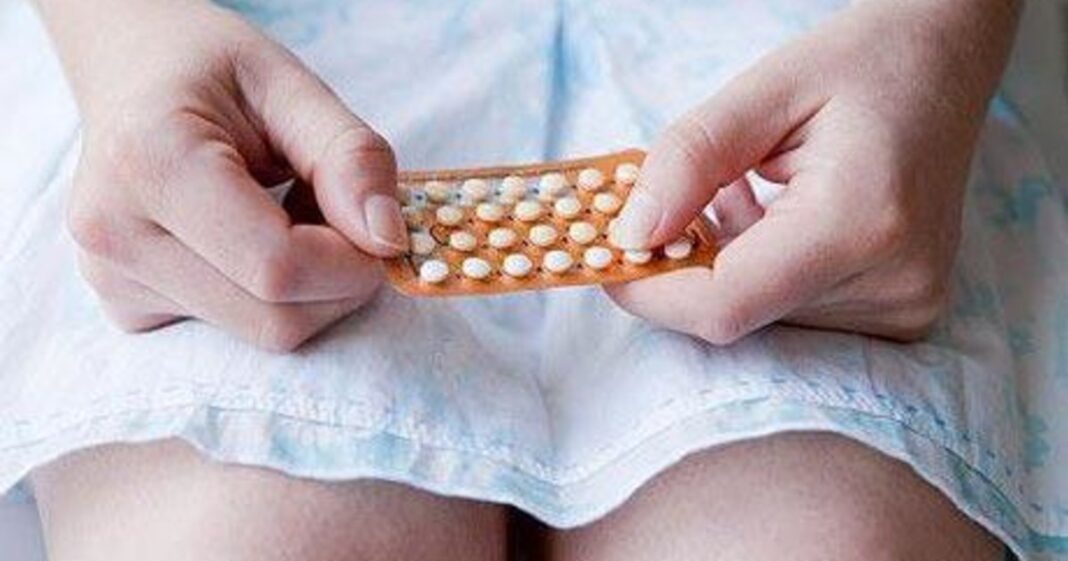 Mujer sosteniendo un blister de pastillas anticonceptivas